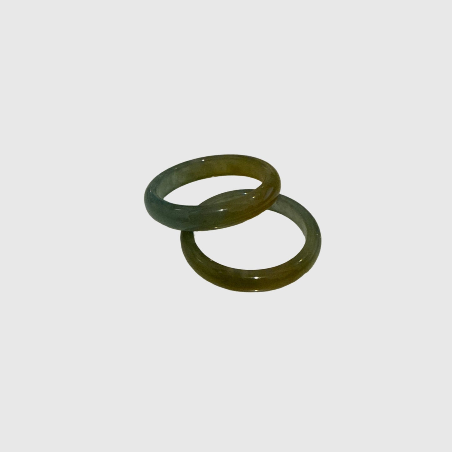 Two yellow green jade ring on a white background