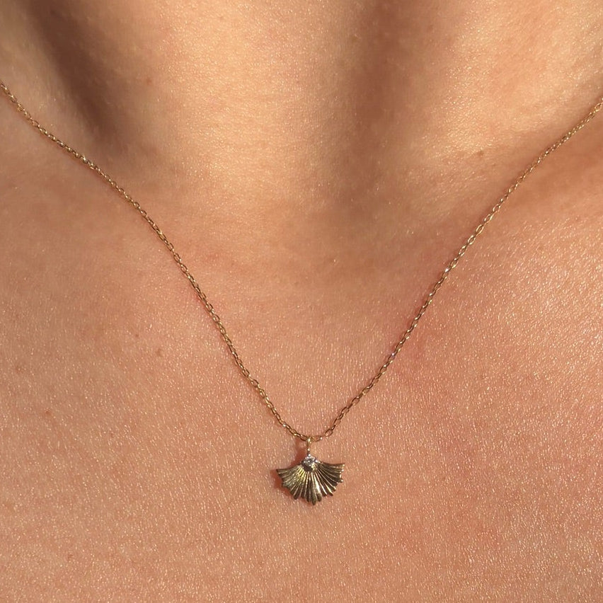 Necklace with a small pendant on a person's neck
